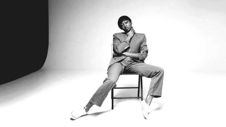 Stylish woman in a tailored suit and sneakers, representing timeless, low-carbon fashion choices